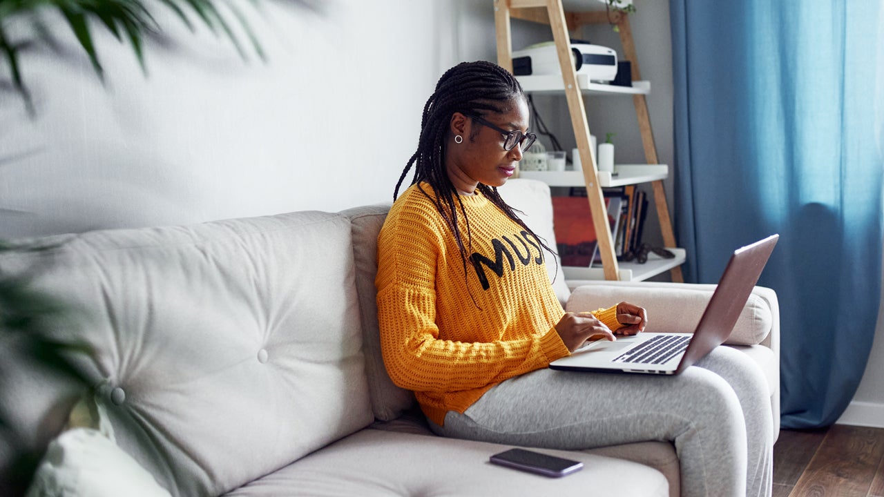 woman on couch using laptop computer