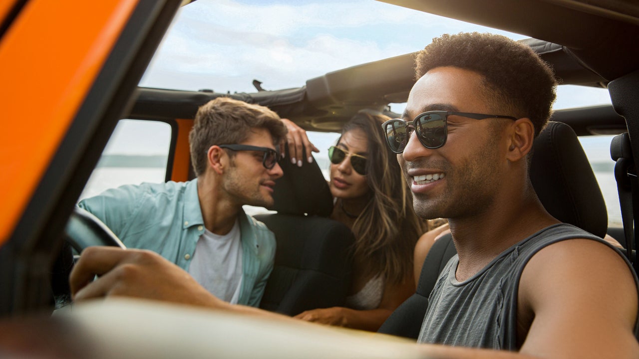 A group of friends driving in a jeep and having a good time.