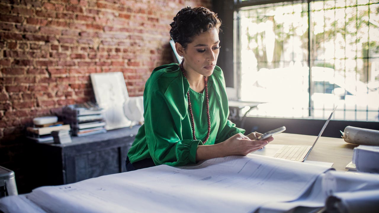 businesswoman at her desk looking at her phone