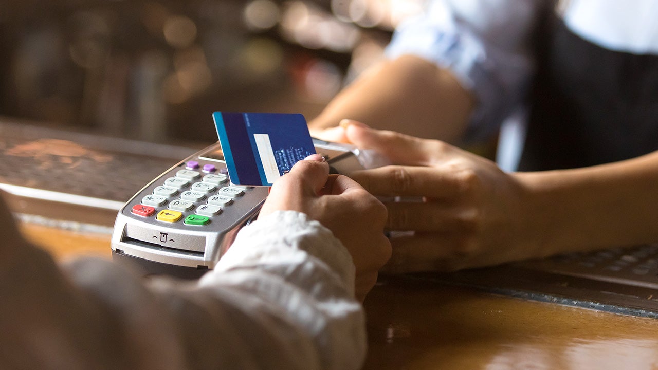 woman using tap to pay at a cafe