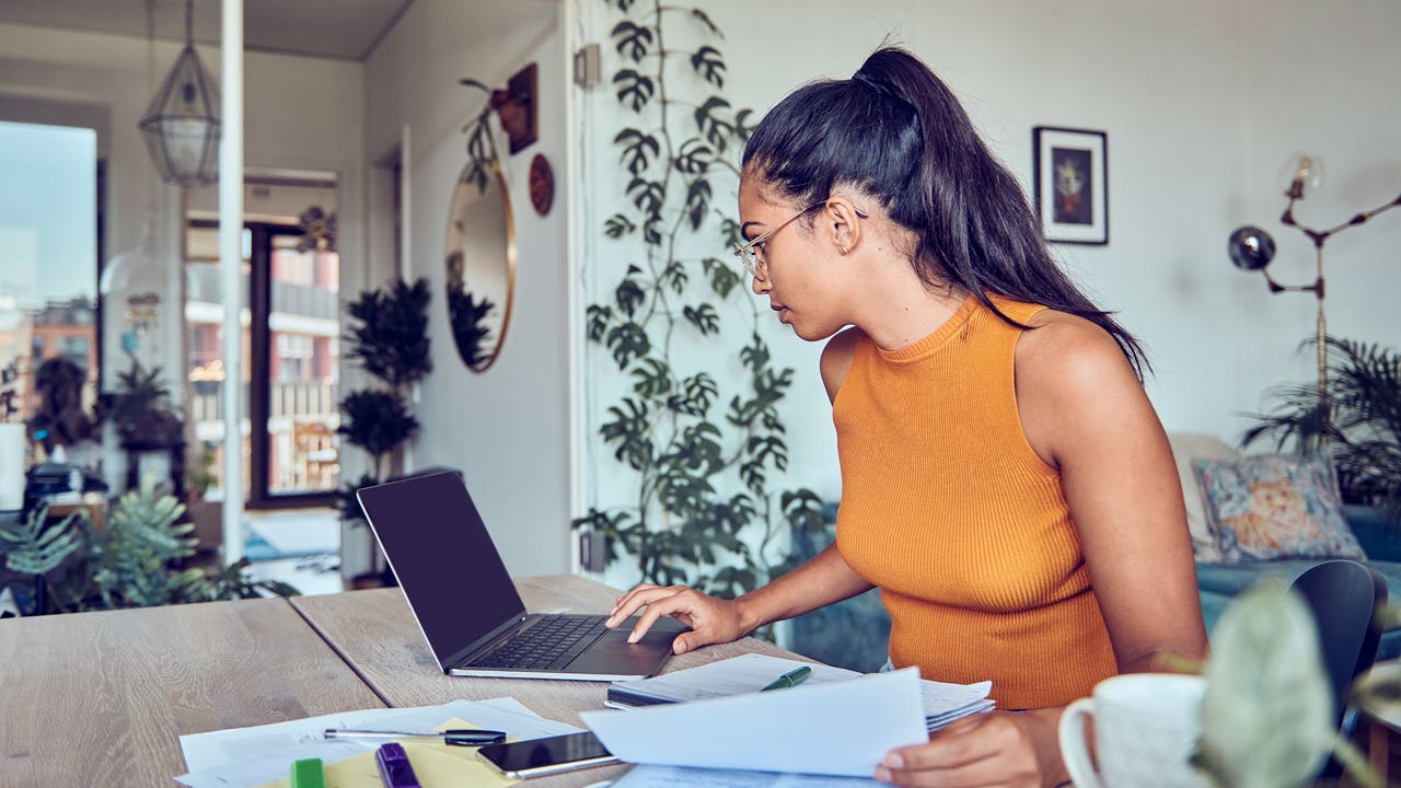 young woman working on finances on her laptop at home