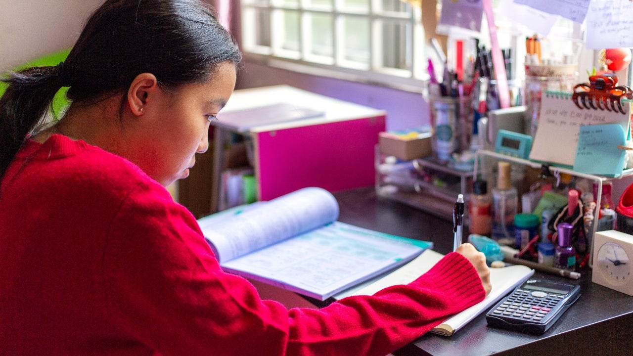 Student studies with a calculator at her desk