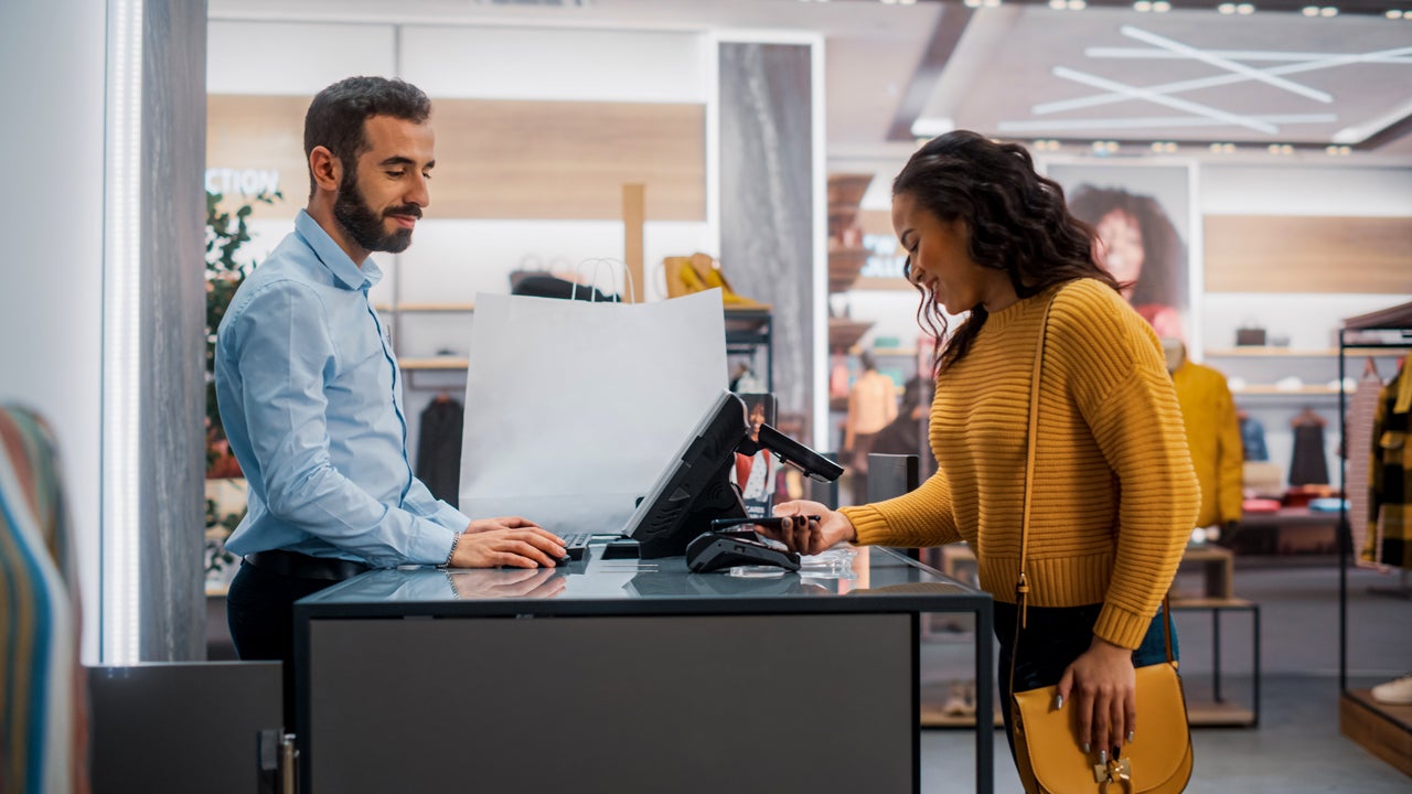 woman paying with mobile payment at a clothing store