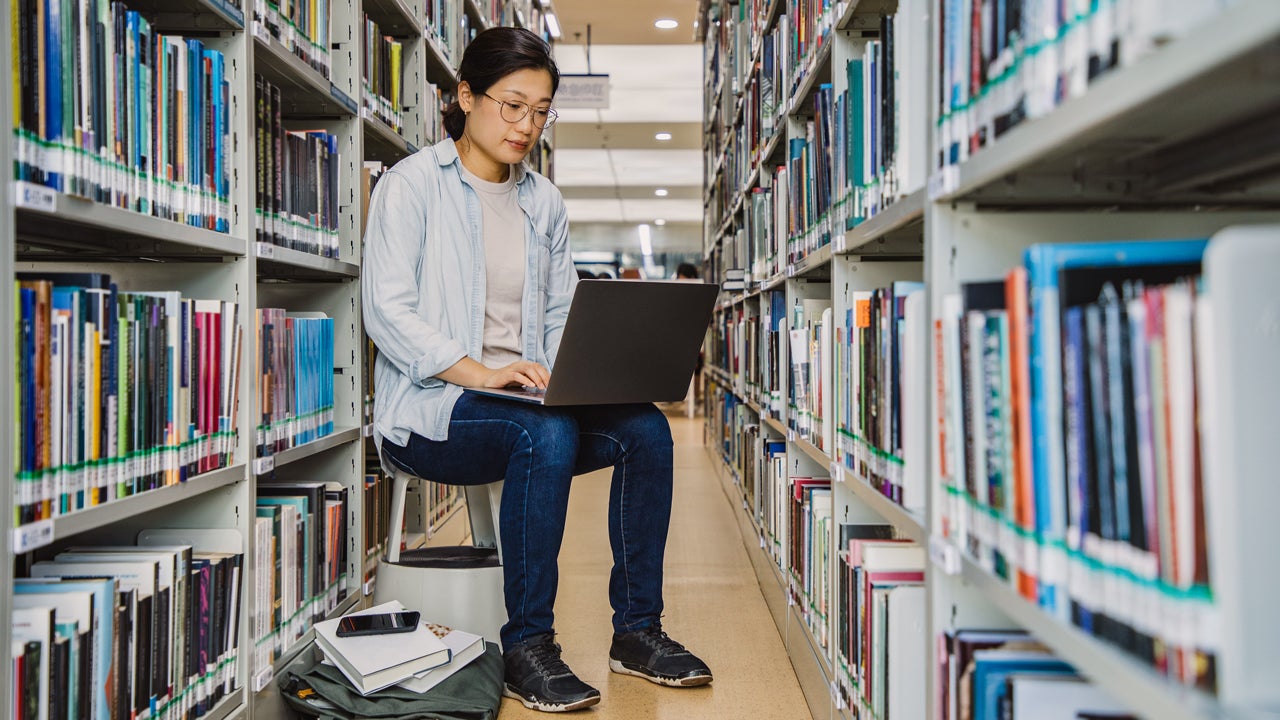 student working on her laptop in the library