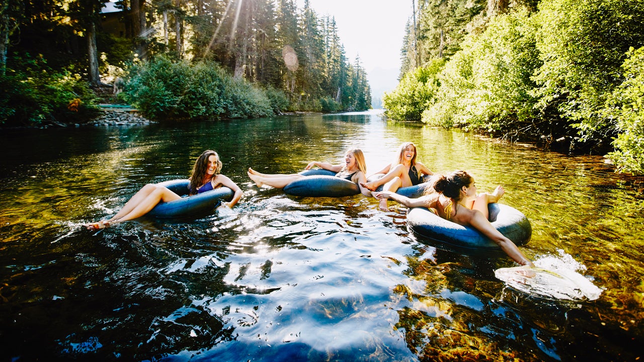 group of friends tubing on the river in summer