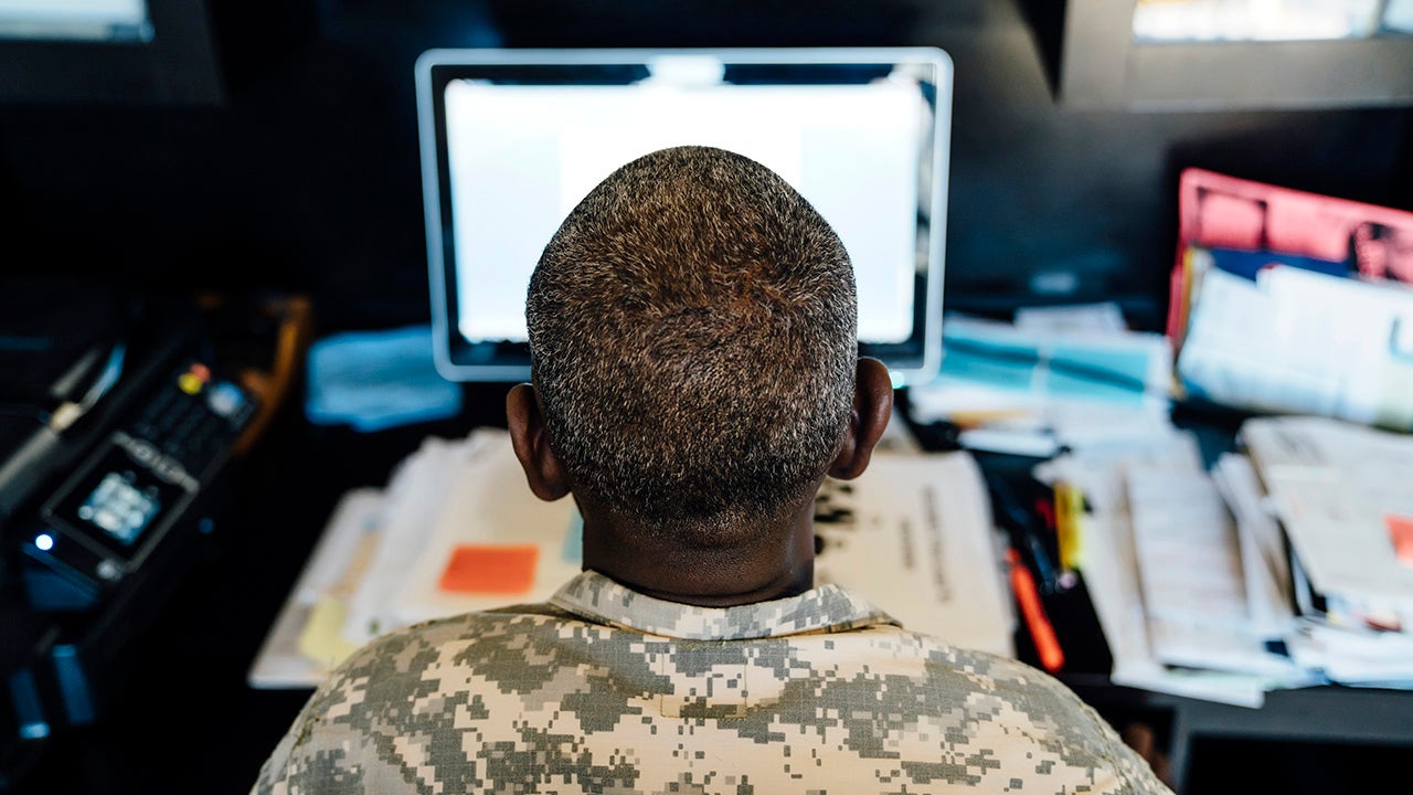 Black soldier using computer