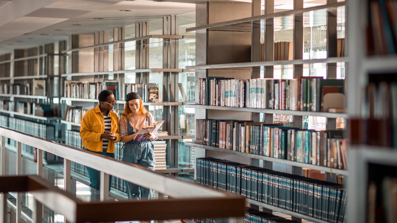 Two students walk through college library