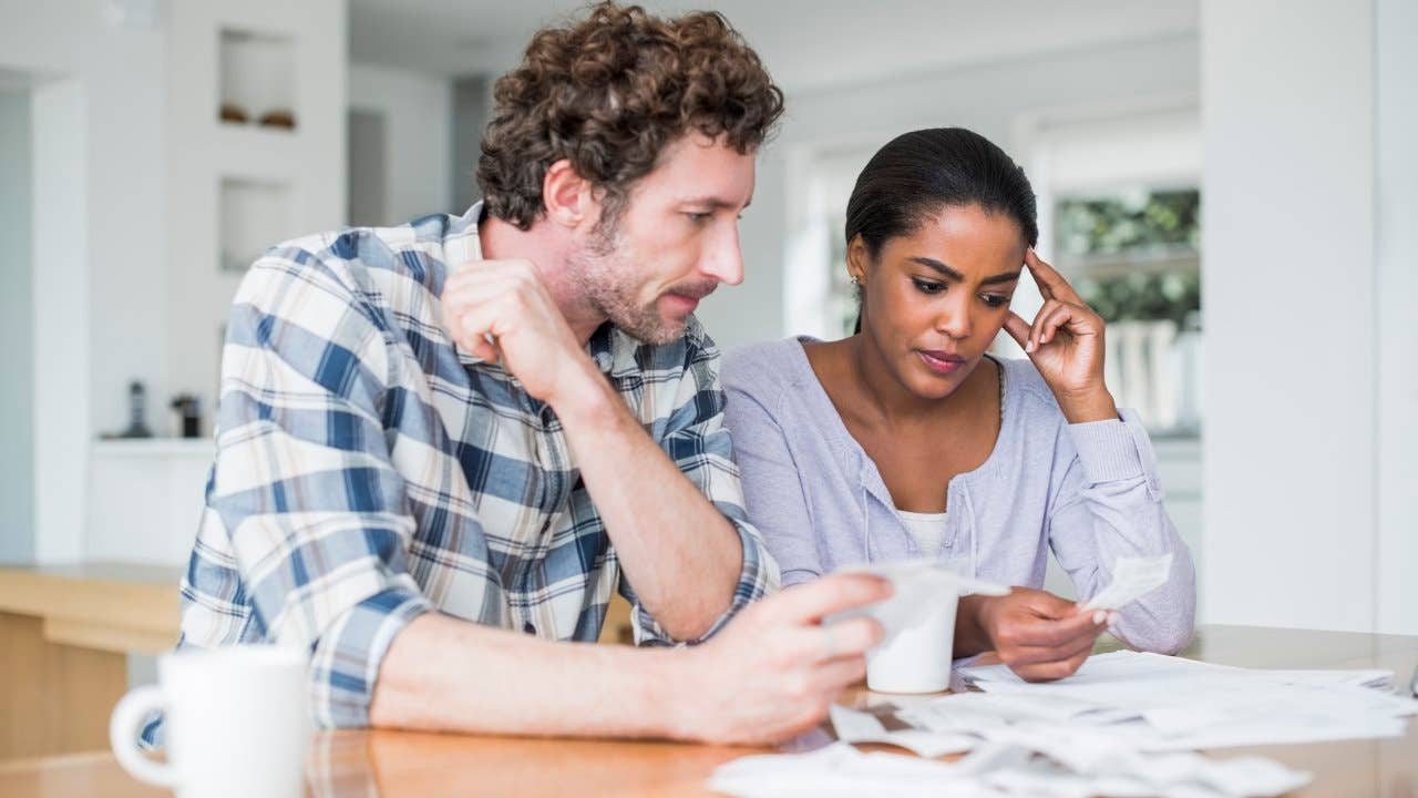 Tensed couple looking over bills