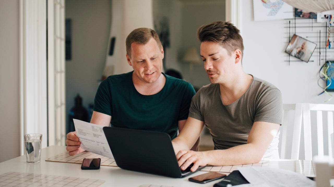 Two men sit with paperwork at a table