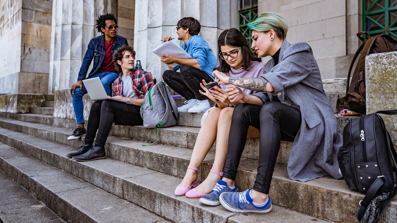 college students studying on some steps