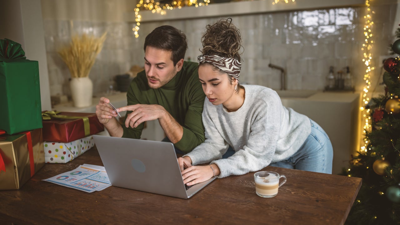 Young couple managing expenses and bills at home after holidays.