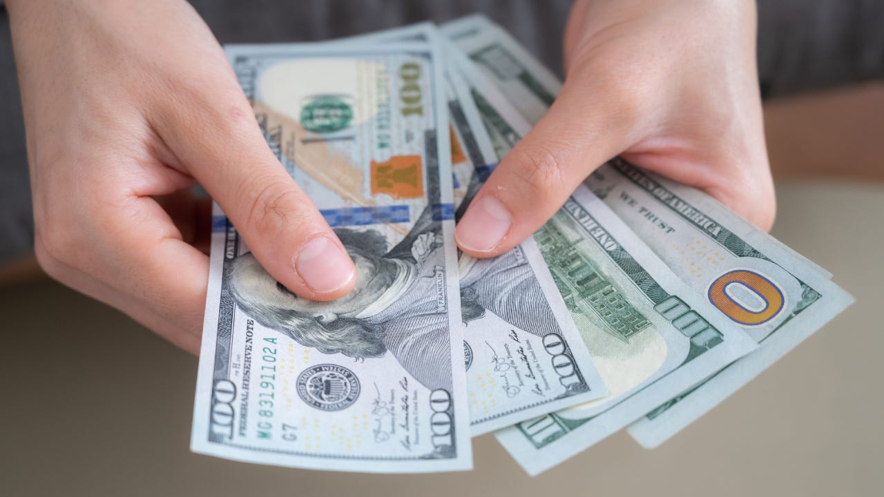 Close up of someone hands holding and counting American dollar banknotes in her hand