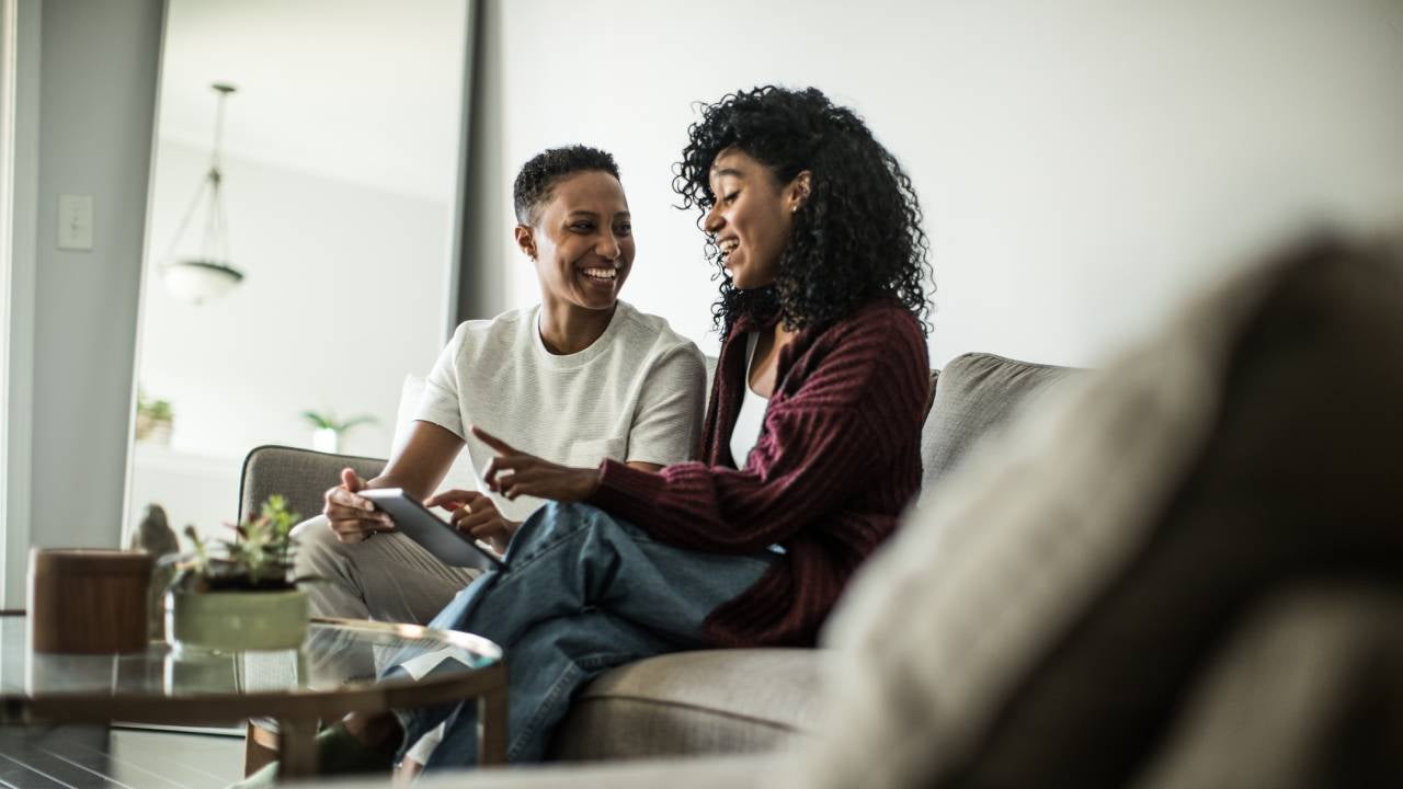 Lesbian couple at home using digital tablet