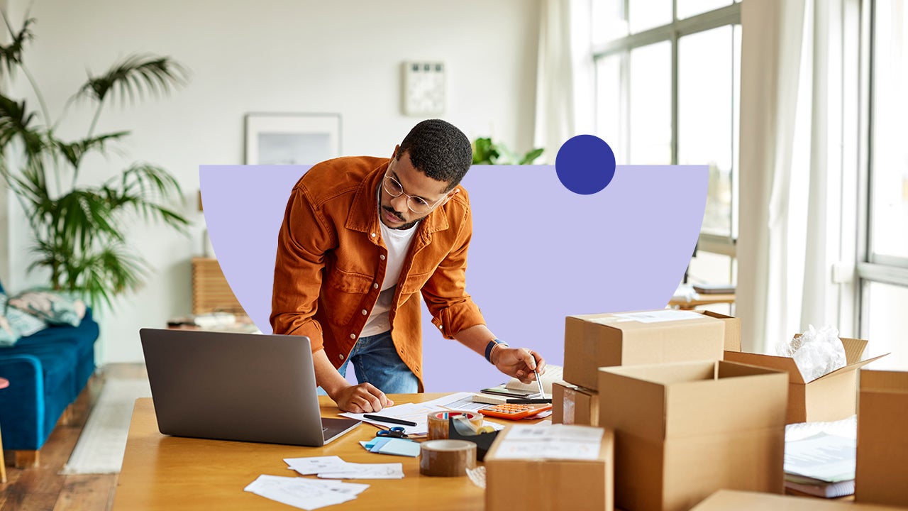 design image of an adult leaning voer a table looking at laptop and there are boxes on the table