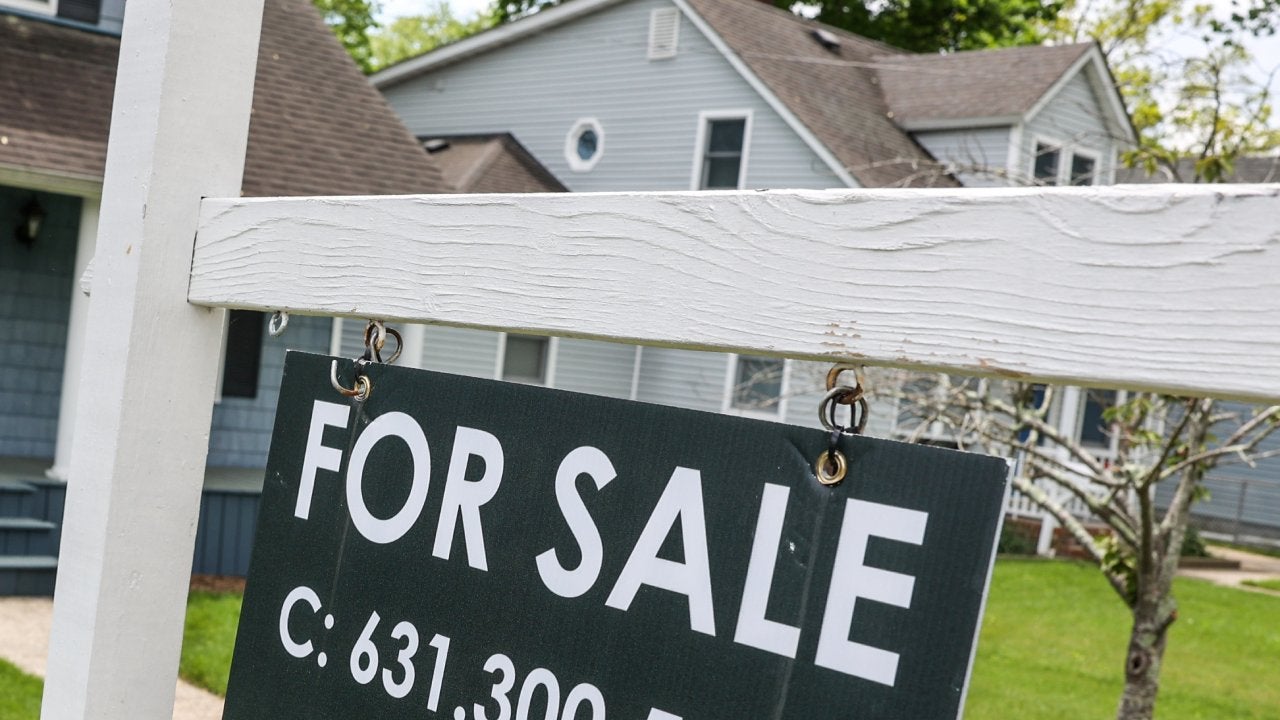 For Sale sign hangs in front of Patchogue, New York house