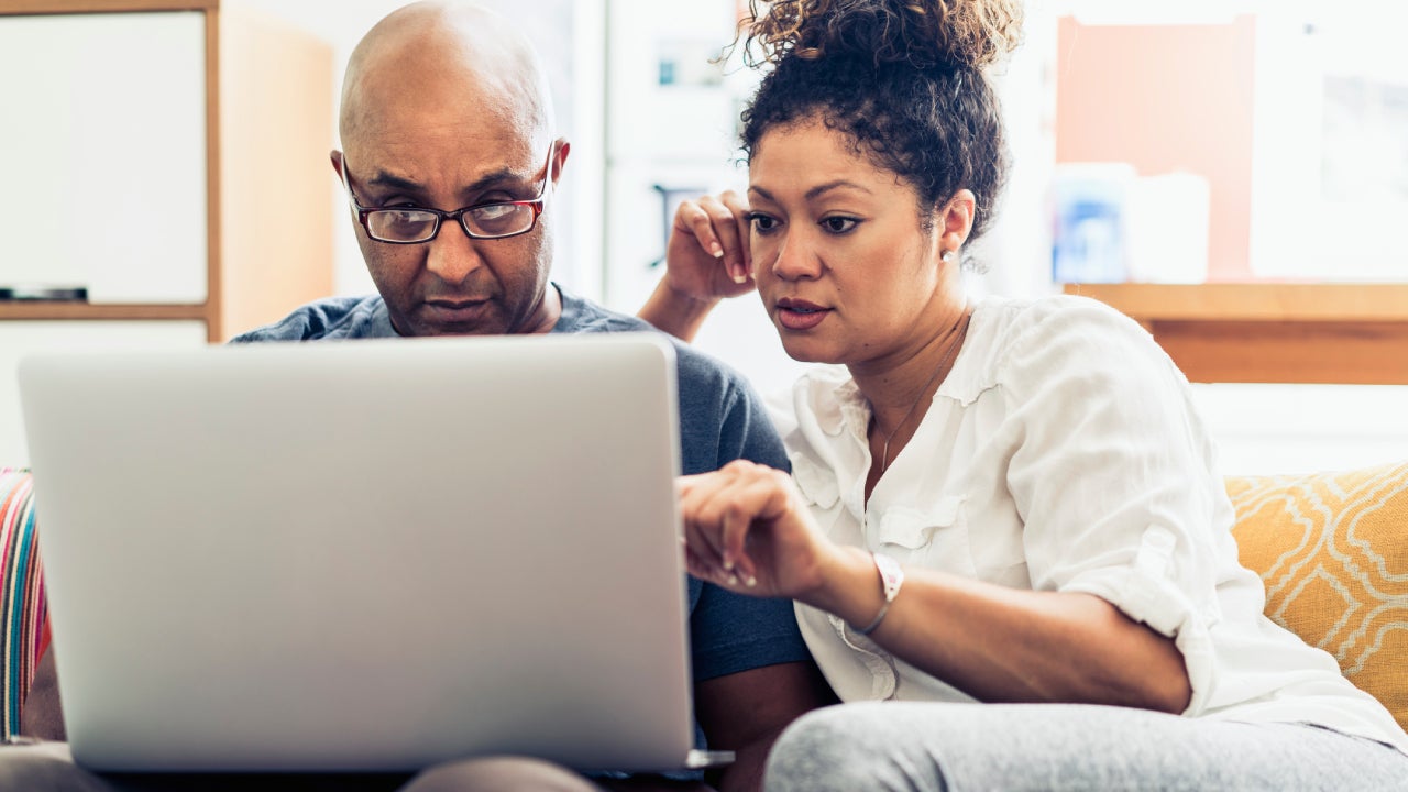 Couple on a couch looking at a laptop