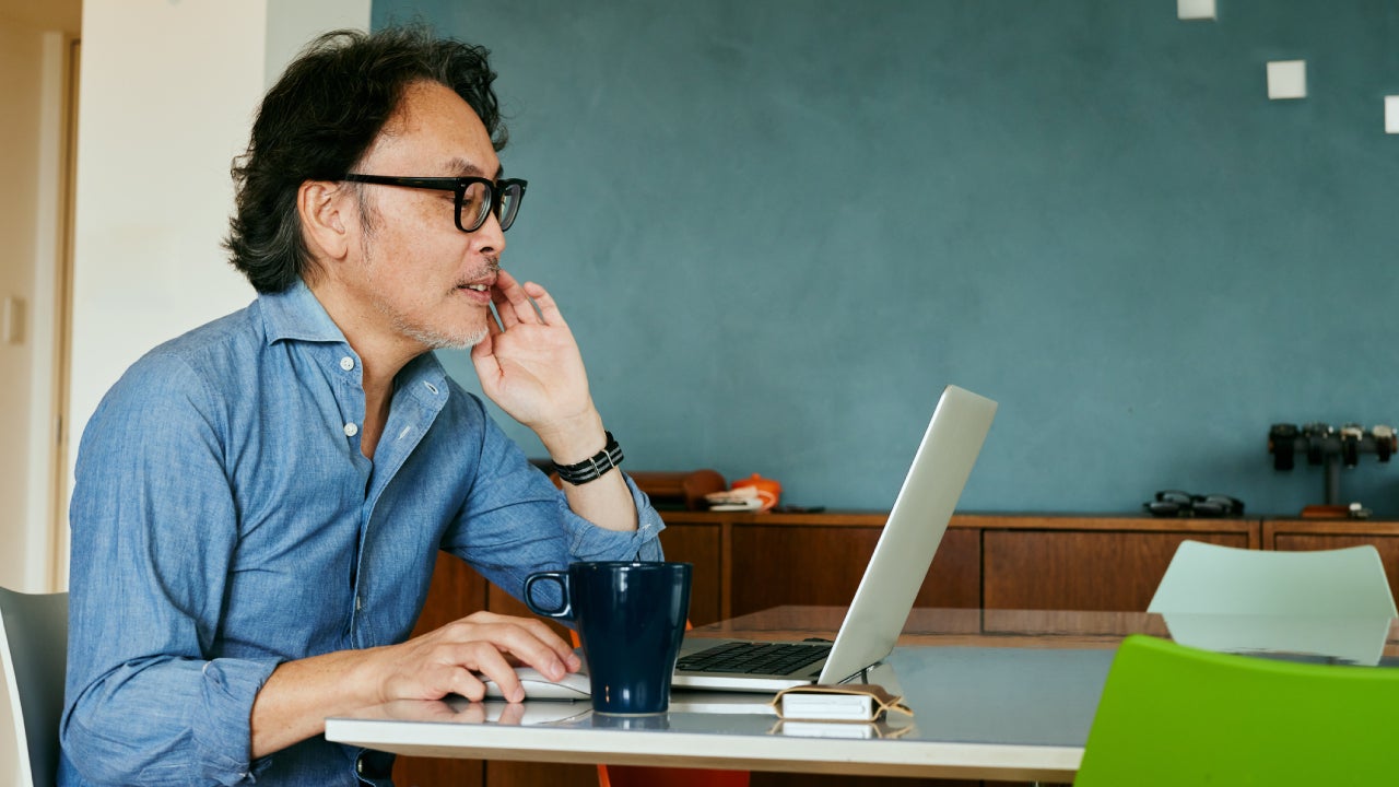 Man working on laptop with a coffee near by