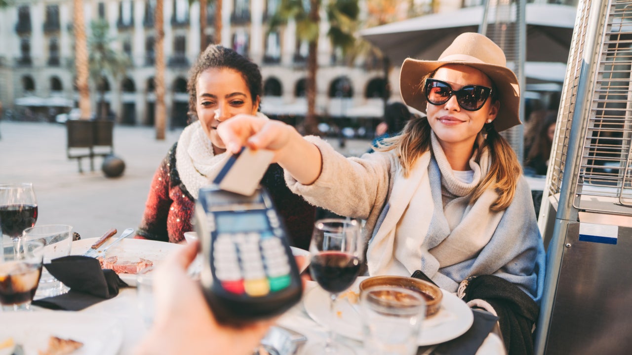 Tourist women in Barcelona paying contactless with credit card