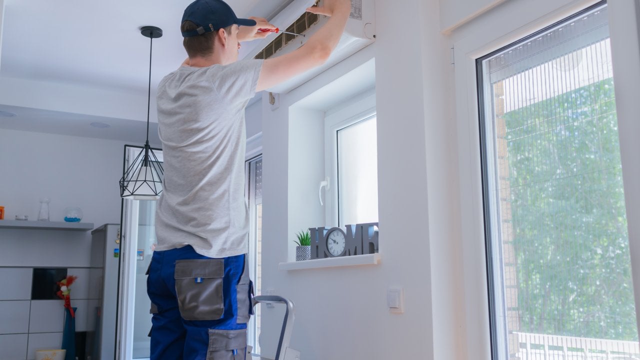 technician repairing air conditioner