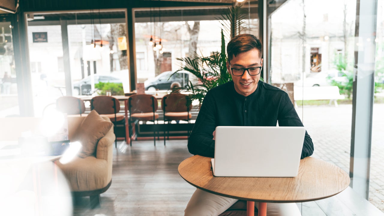 Young professional man working on a laptop in a cafe