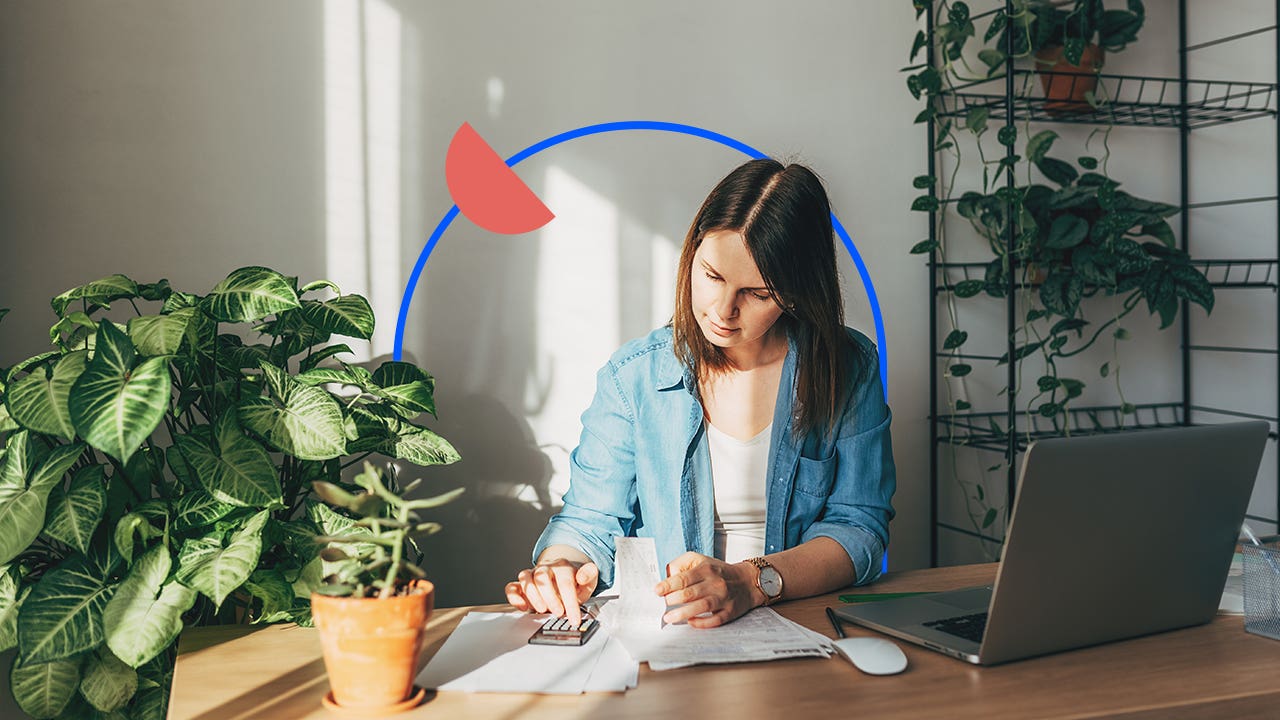 Woman reading papers on table with an illustrated blue circle behind her and an illustrated filled in orange half circle on that circle