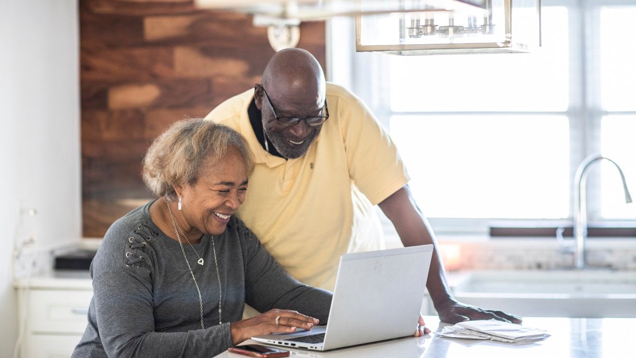 Senior couple using laptop in kitchen