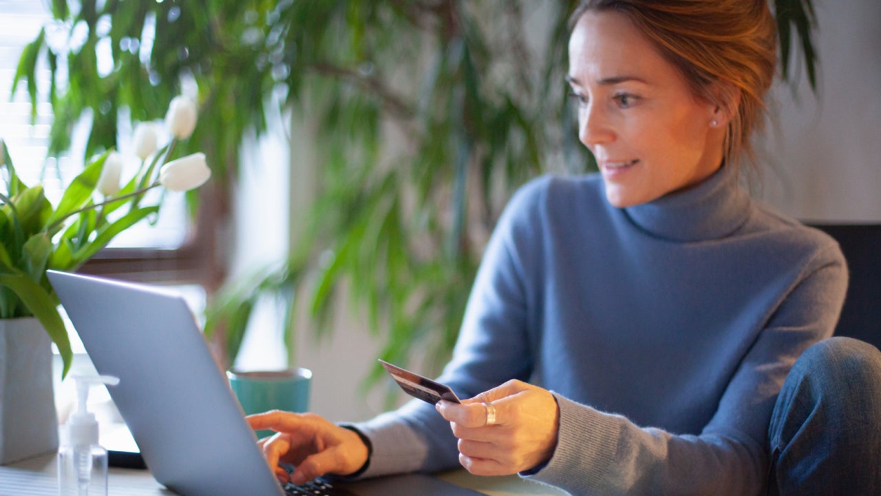 Woman using credit card at laptop