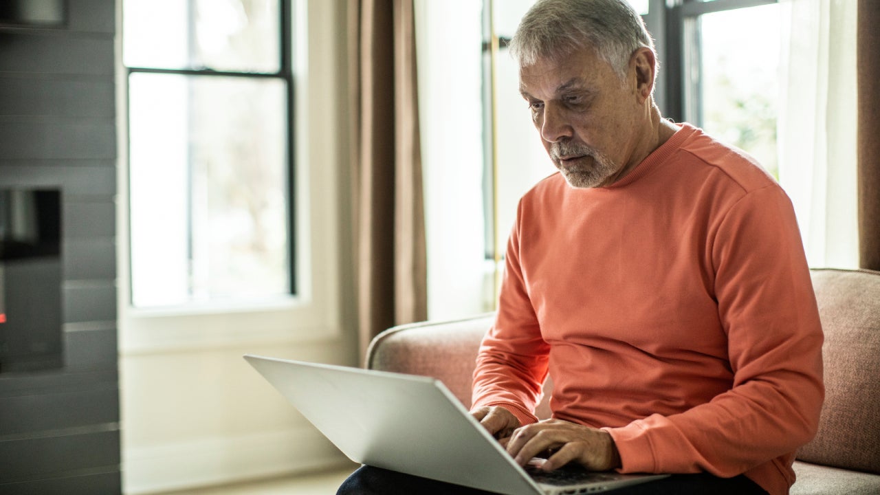 Man using laptop on sofa