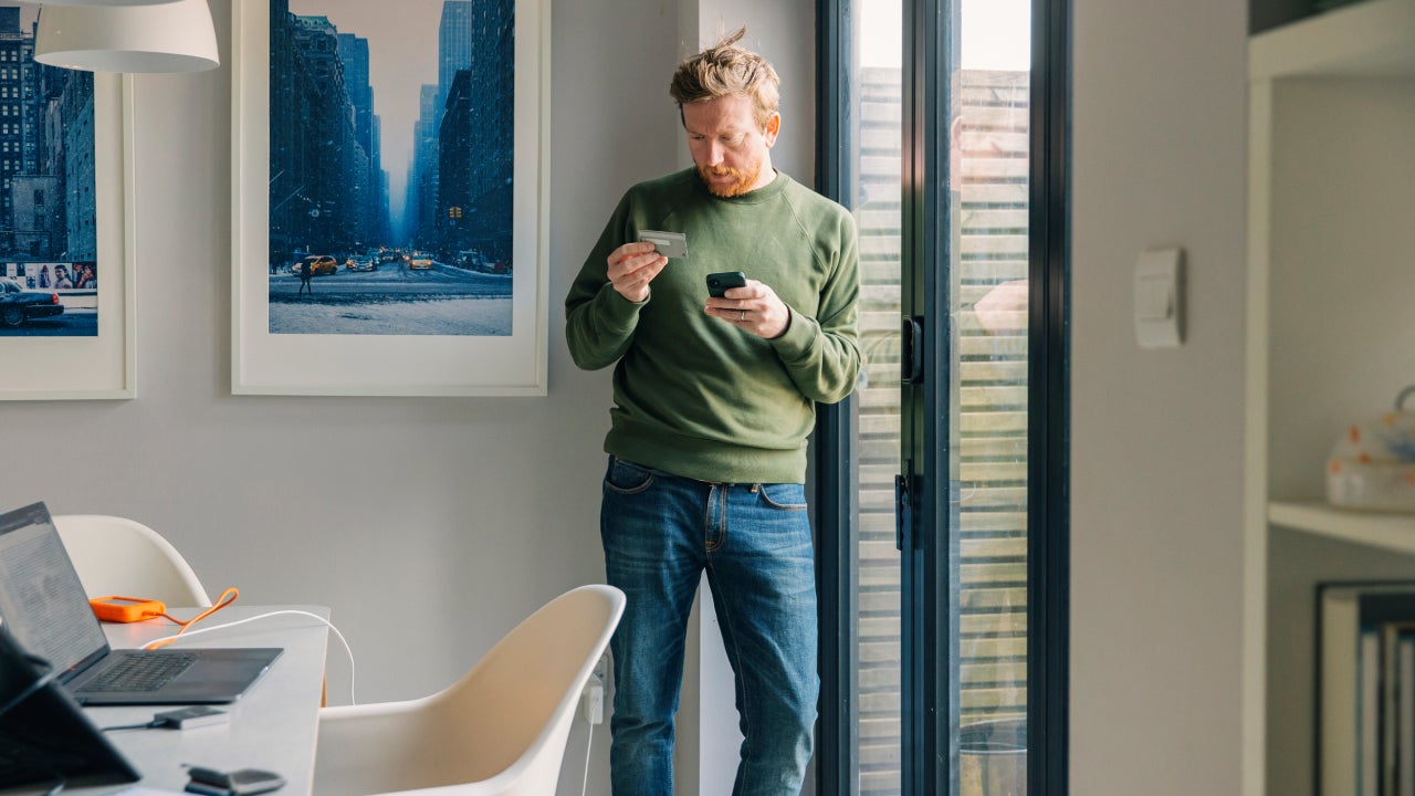 Man making an online payment on his smartphone using his credit card