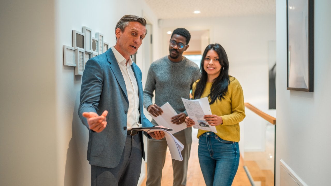 Male real estate agent with a young married couple.