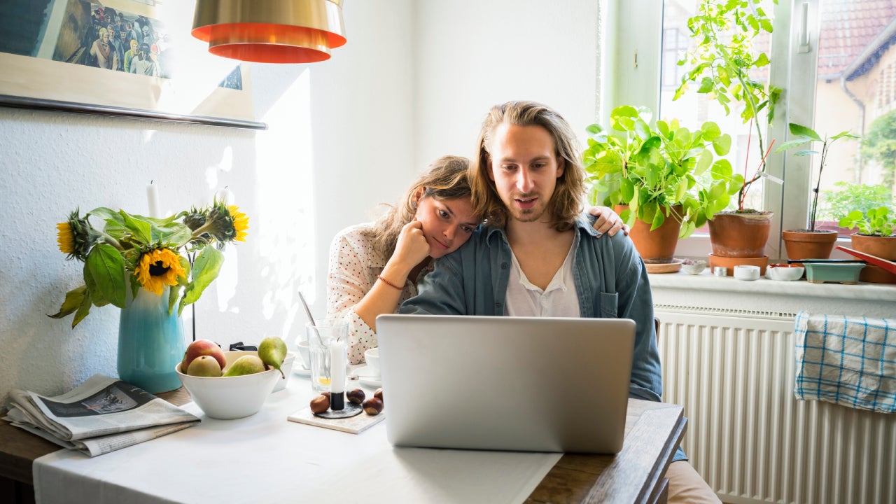 Young couple using laptop in kitchen