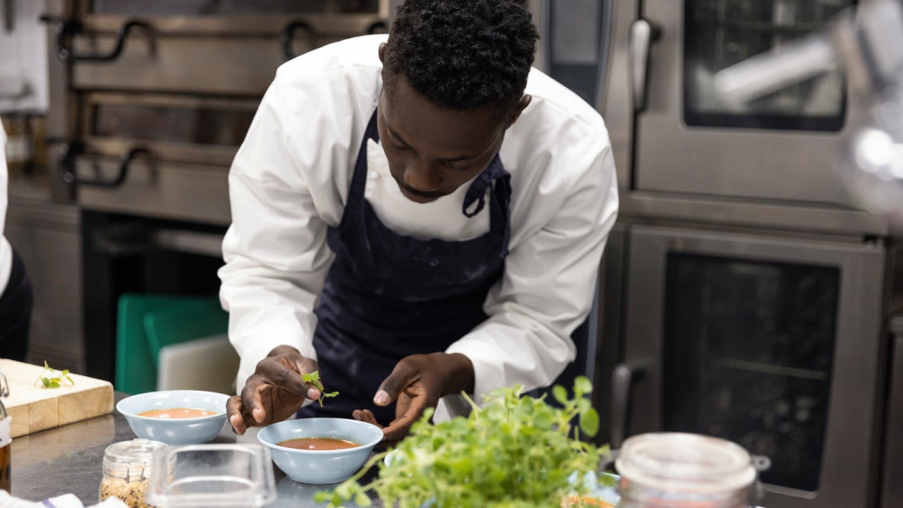 Chef garnishing soup in restaurant kitchen