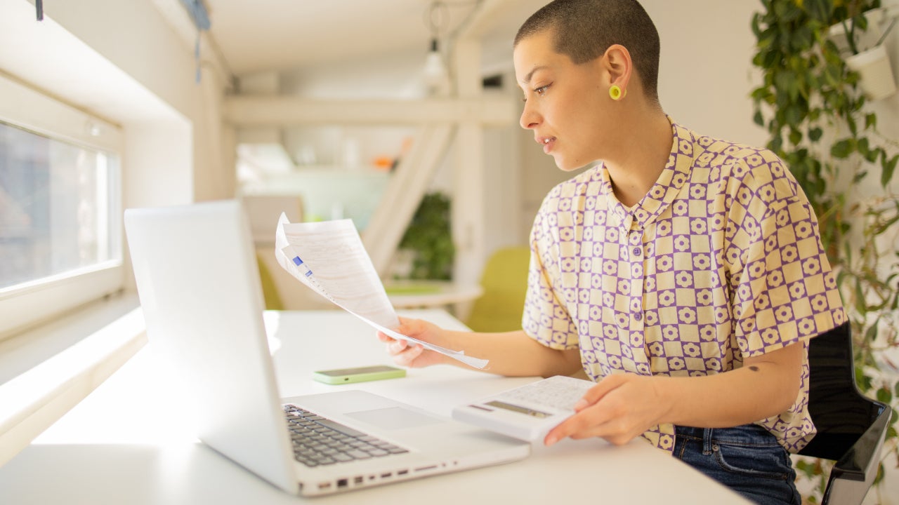 Business owner looking over documents in front of a laptop