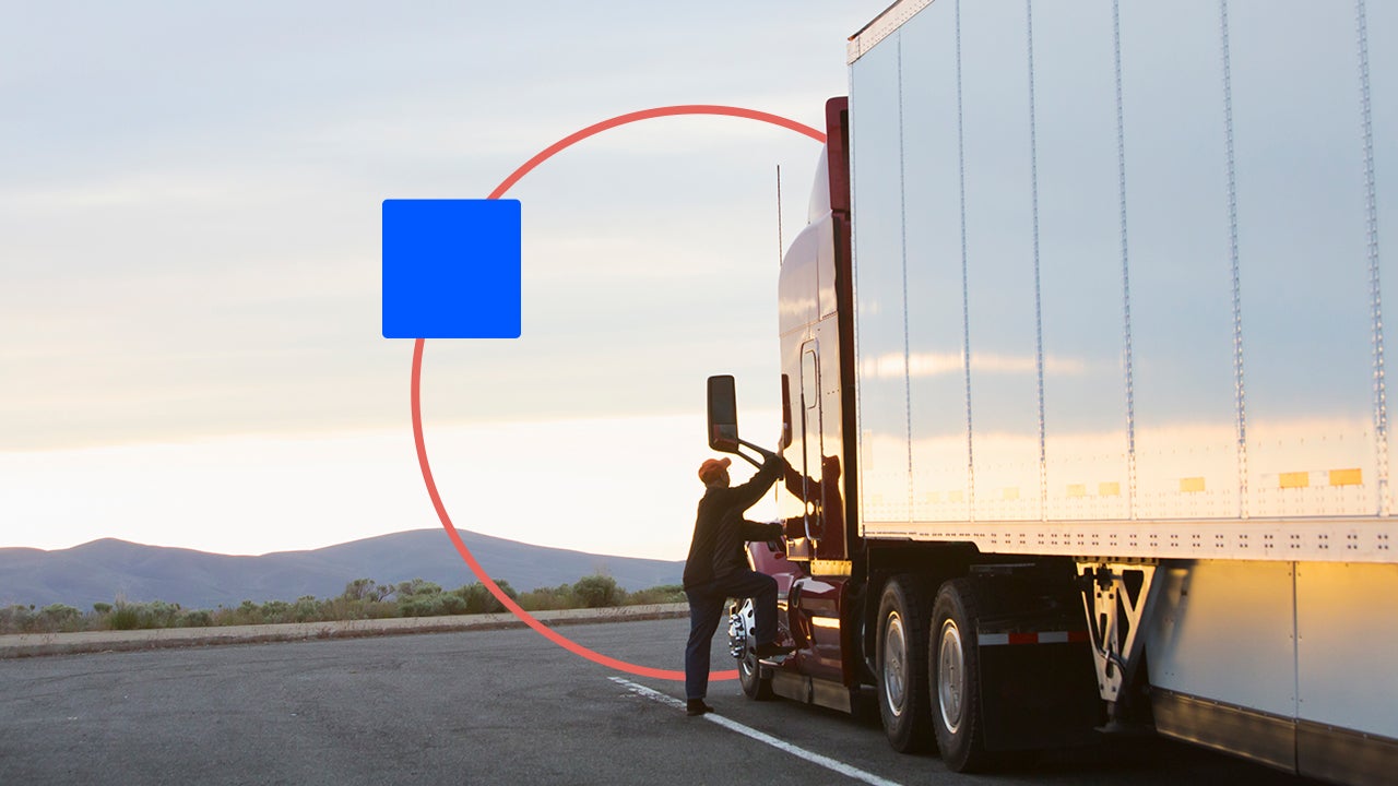 A truck driver steps up into his truck