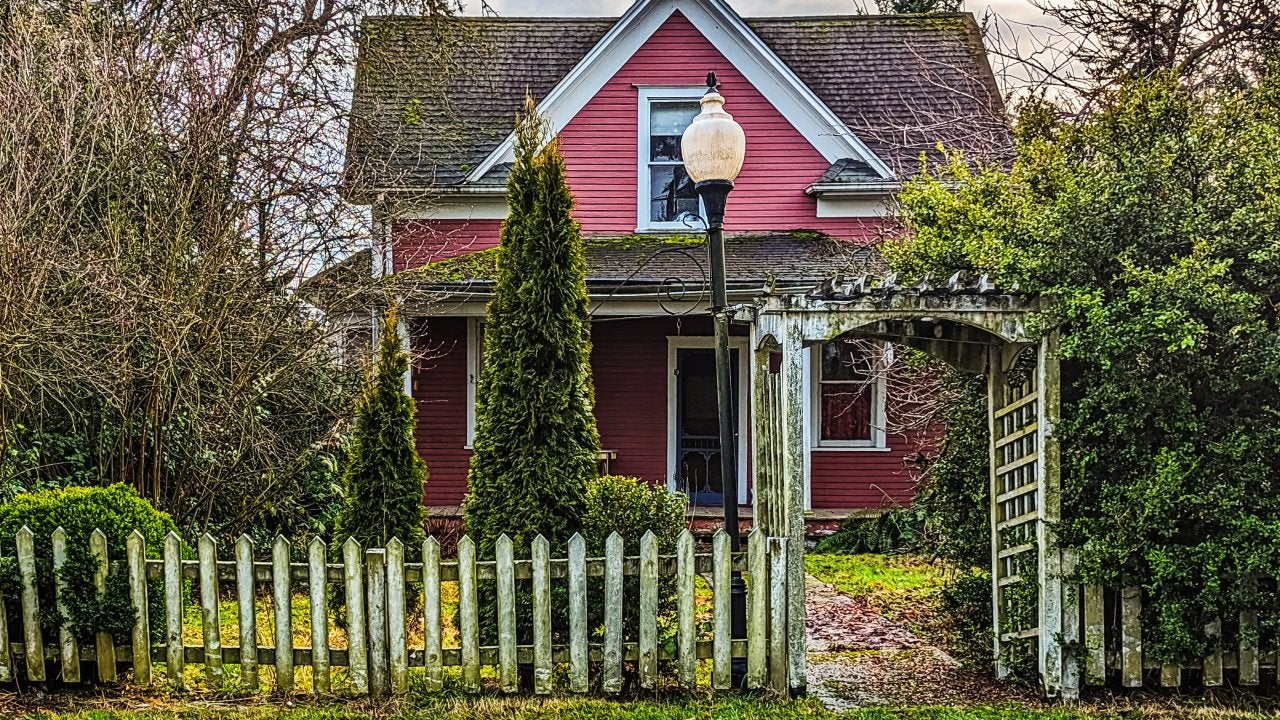 hoto of an old red two-story house in need of maintenance, while still maintaining a quaint appearance