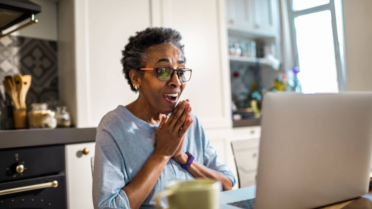 Happy woman reacting to news from her laptop