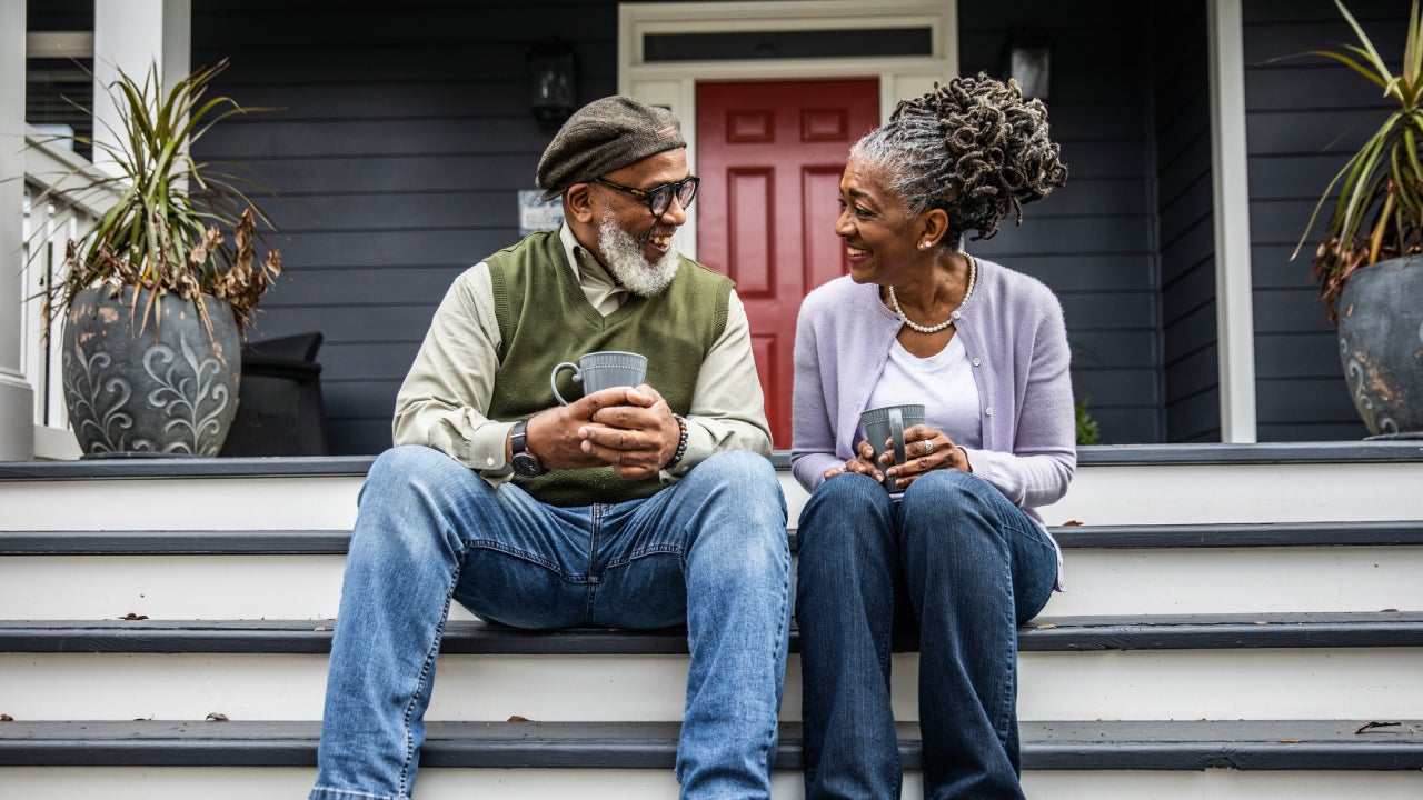 Older coupling drinking coffee on a front porch