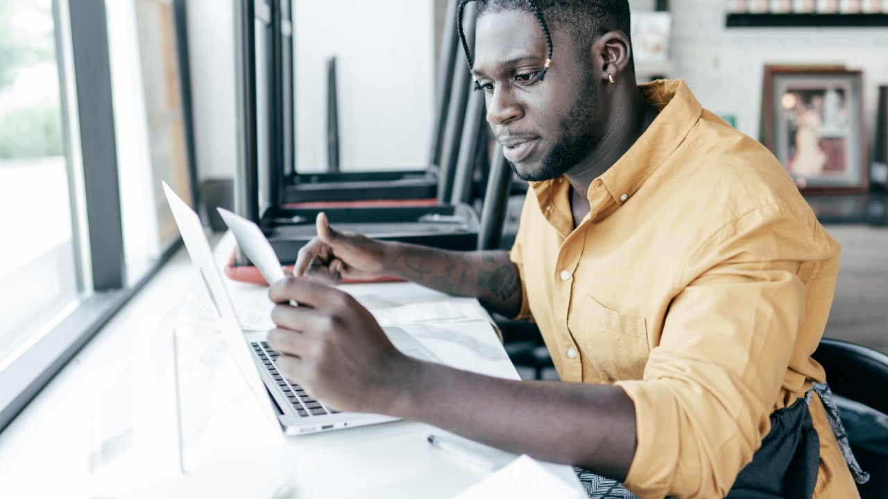 Man calculating taxes for a small business on a laptop.