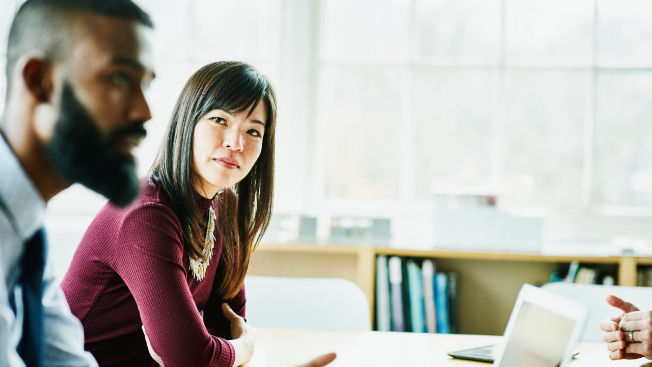 Businesswoman listening to colleague present during client meeting