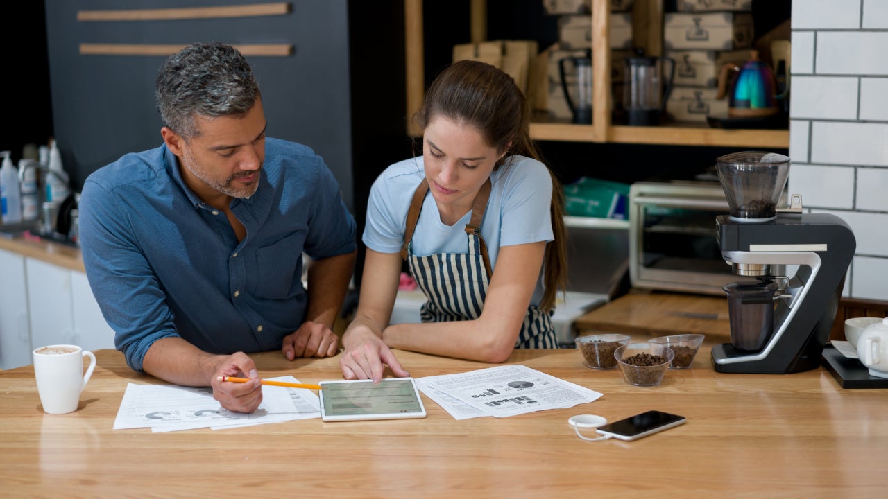 Man and women review documents at a workshop table.