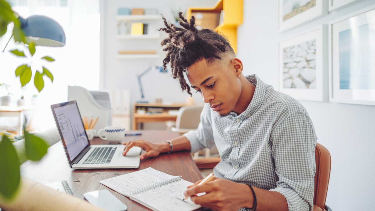 Young man writing down notes in an office