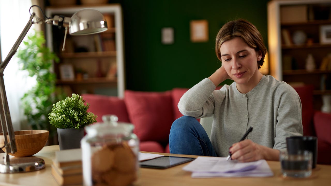 Women using digital tablet to check her finances at home office