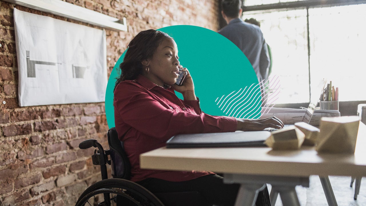 A woman in a wheelchair works in her office.