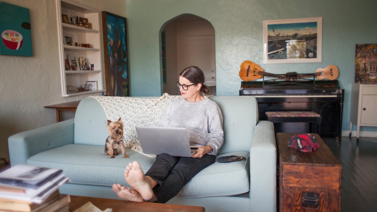 Woman sitting on couch with laptop computer