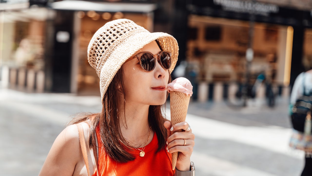 Female tourist eating ice cream cone on the street