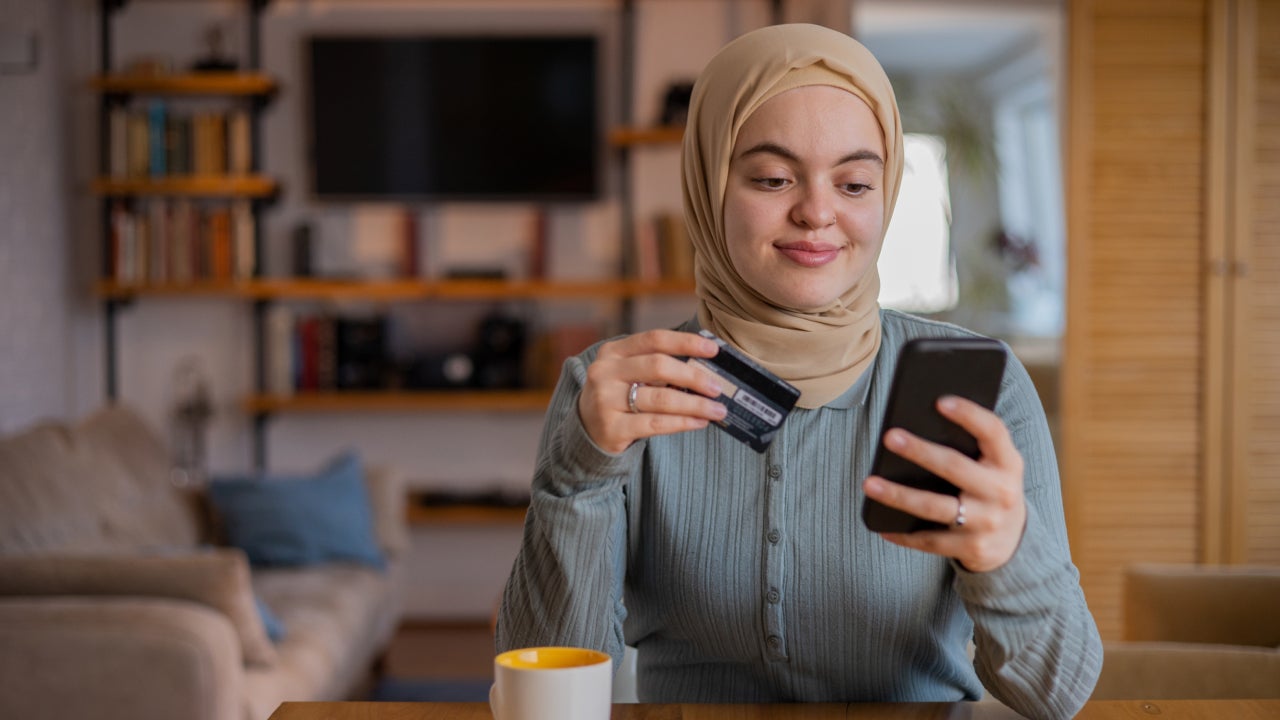 Woman holding credit card and shopping on phone