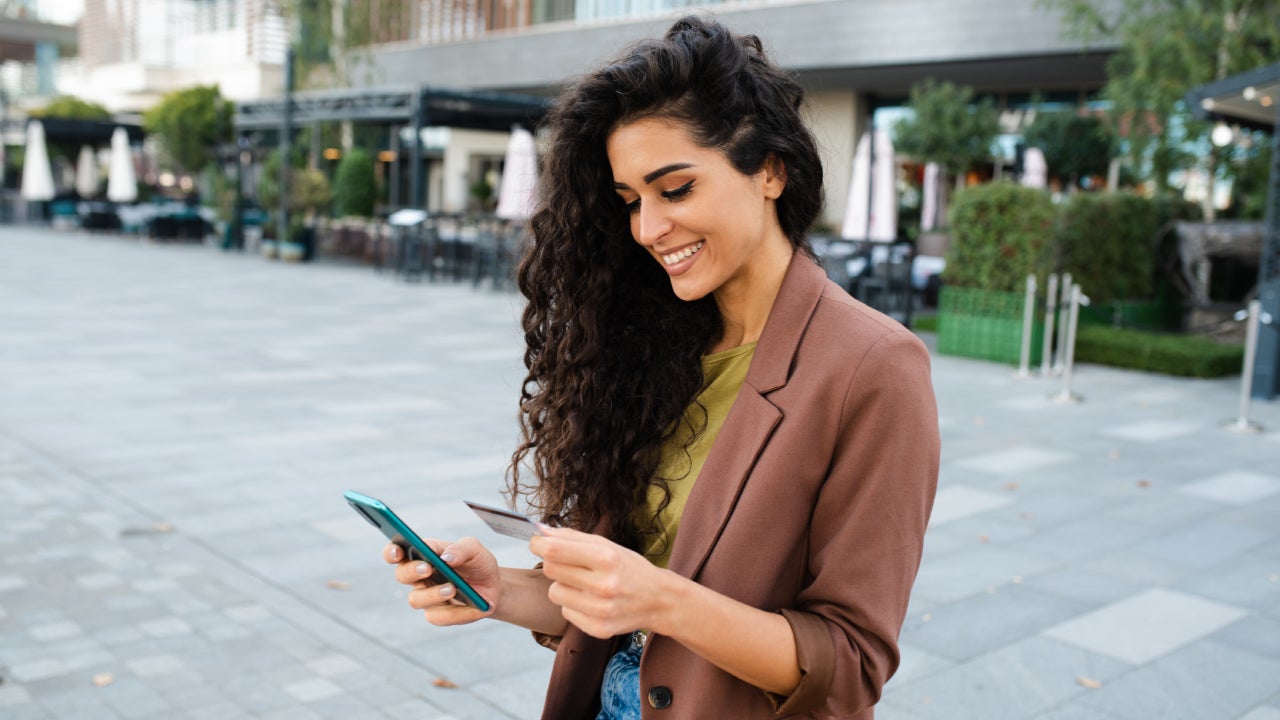 Portrait of a young woman enjoying at the cafe and shopping online