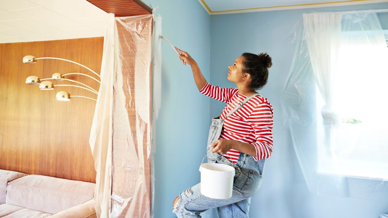 Pregnant woman in bib overalls renovating room