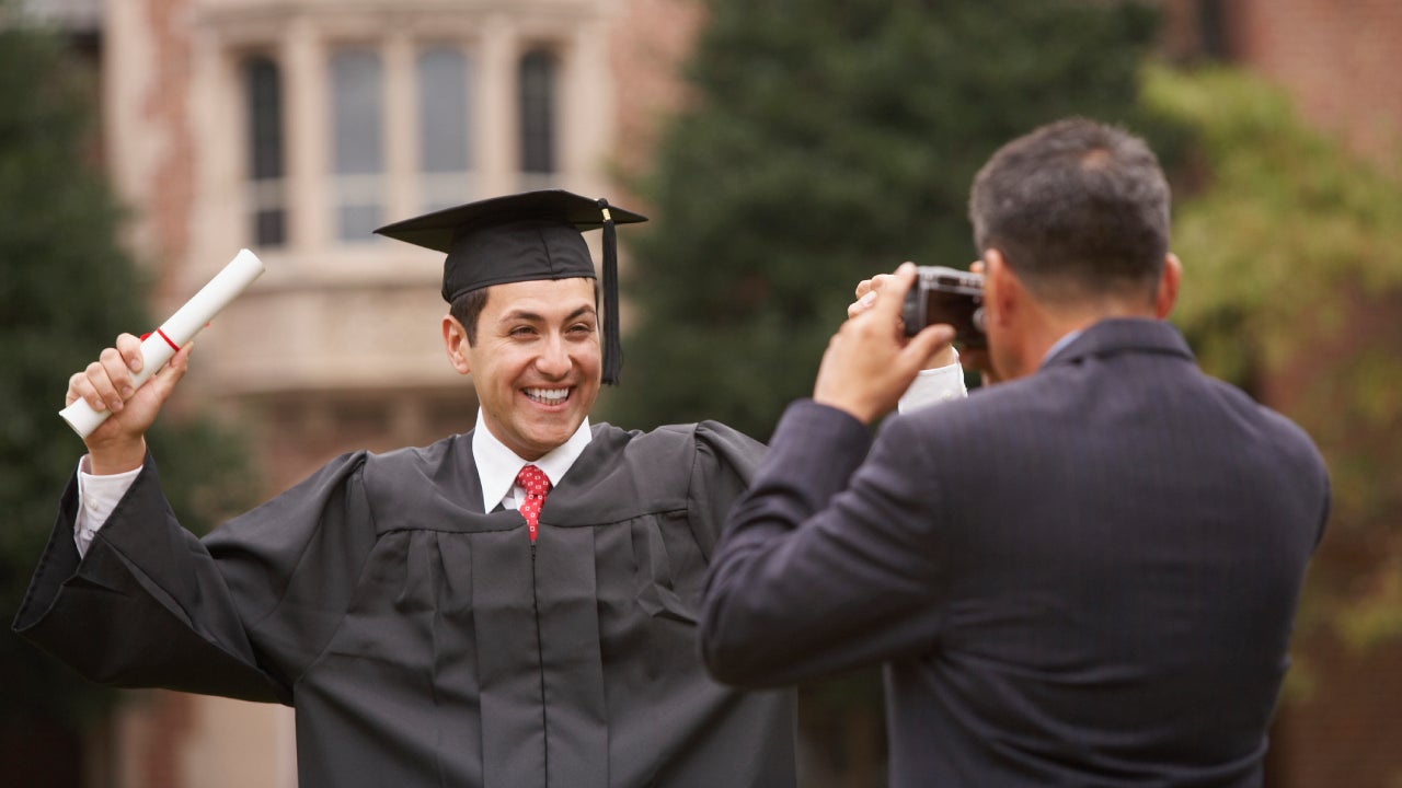 College graduate in cap and gown with diploma