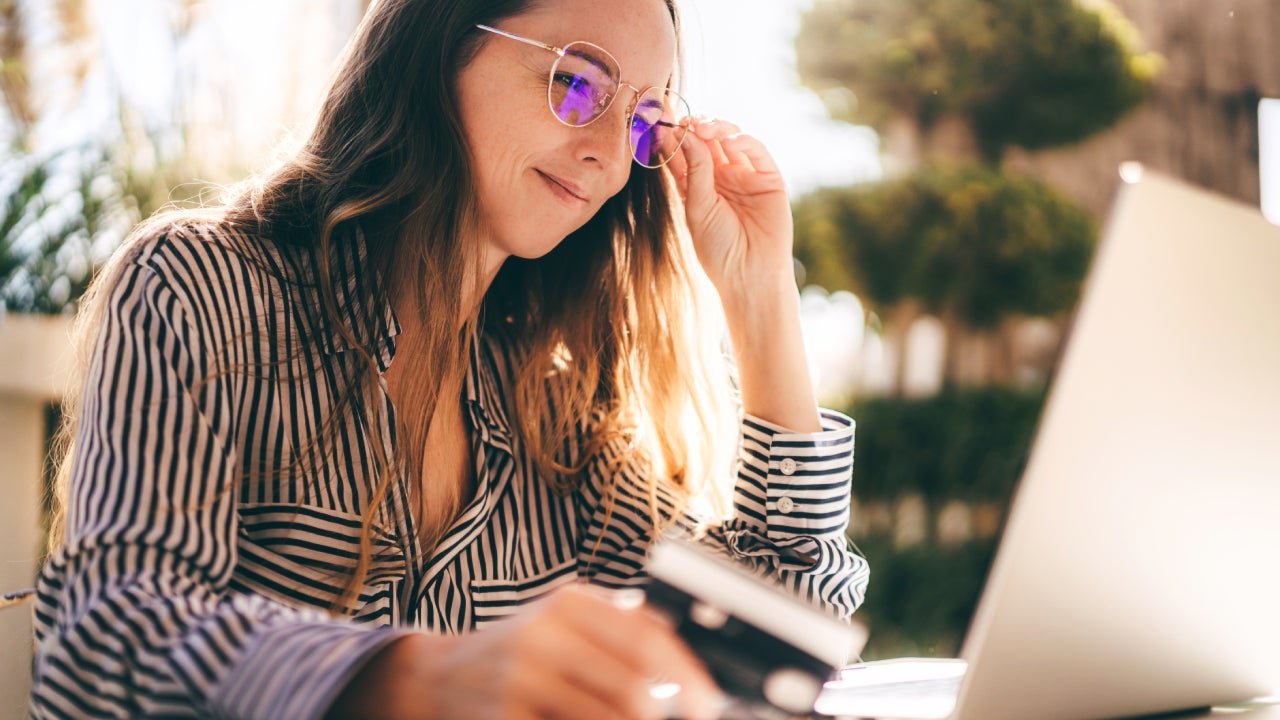 Beautiful businesswoman is working on the laptop, making online purchases with a card